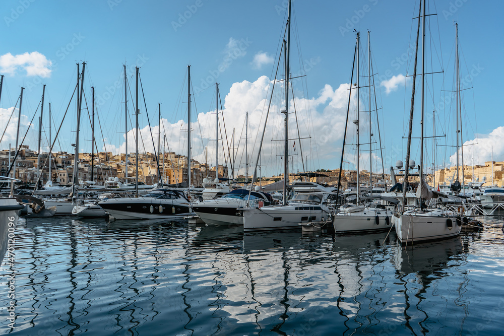 Luxury boats and yachts in the harbor. Sunny summer day. Holiday high-class lifestyle travel concept. Boat trip in the Mediterranean.View of expensive sailing yachts at the pier.Marine dock.