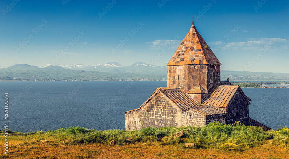 Panorama from the peninsula viewpoint to Sevanavank Monastery and chapel overlooking famous Sevan lake at sunny weather