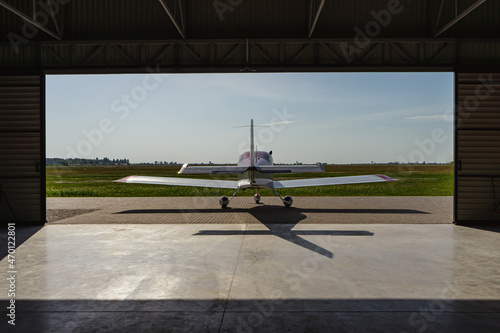 A small private jet on the landing site before takeoff. Back view.