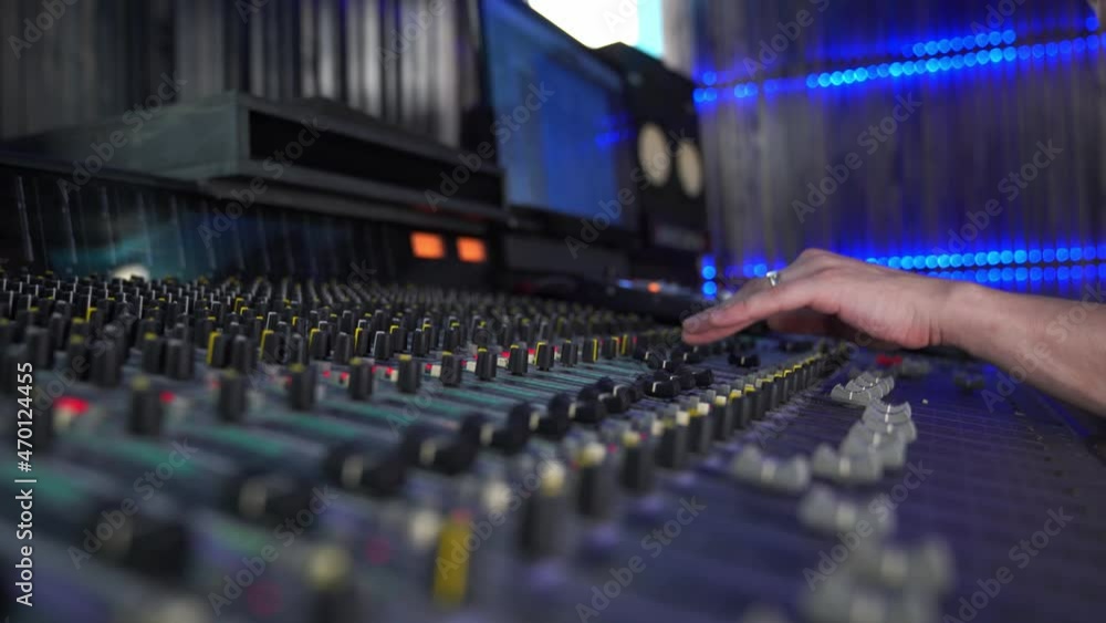 Professional mixing console in the studio, female hand controls the sound, with LED backlight. High quality 4k footage Professional mixing console in the studio, female hand controls the sound, with LED backlight. High quality 4k footage