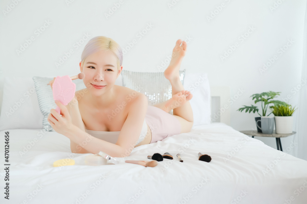 portrait beautiful asian woman on the bed, make up beauty concept and hair highlights with blush brush portrait beautiful asian woman on the bed, make up beauty concept and hair highlights with blush brush