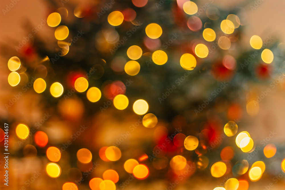 Blurred Christmas lights with bokeh effect Background. Abstract defocused colorful lights. Golden glittering Xmas lights.Circular reflections of Christmas lights. Luxury glowing holiday scene