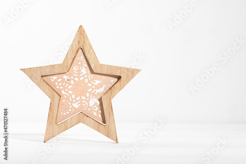 wooden christmas star decoration on a white wooden backgroud with copy space, eco wooden Christmas decor for home, waste-free festive decoration concept