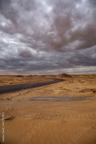 Empty road in the black desert of Egypt in a storm