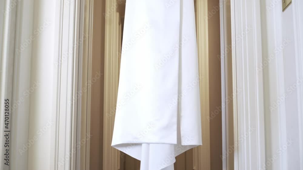 Light and delicate white brides dress on a hander. Wedding dress, indoors Light and delicate white brides dress on a hander. Wedding dress, indoors
