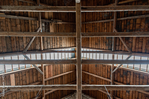 Obraz na plátně Bottom view of an old beams and wooden roof. Inside an old barn.