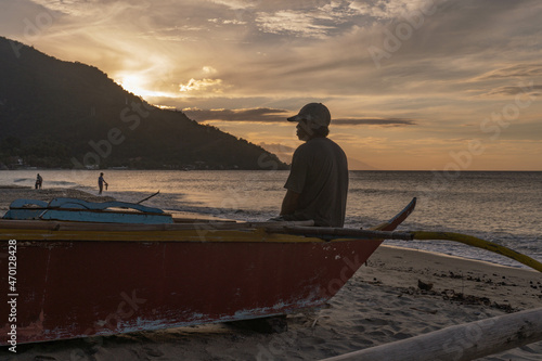 Traditional fisherman watching the sunset and waiting for the tide. The fish are scarce and he might only carch a few for about four hours'work. Aninuan, Mindoro, Philippines Novmber 2021