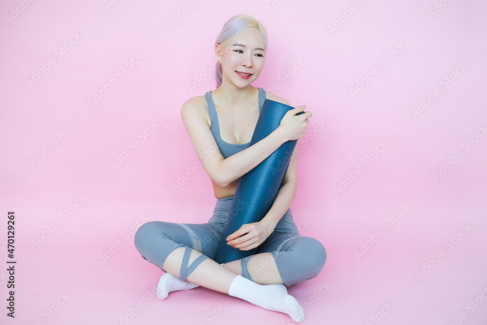 beautiful asia woman on pink background with mat yoga, fitness sports and recreation concept beautiful asia woman on pink background with mat yoga, fitness sports and recreation concept