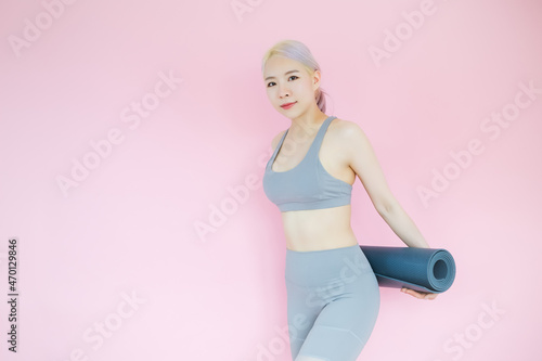 beautiful asia woman on pink background with mat yoga, fitness sports and recreation concept