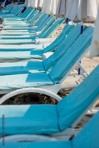 Empty blue sunbeds on a modern beach
