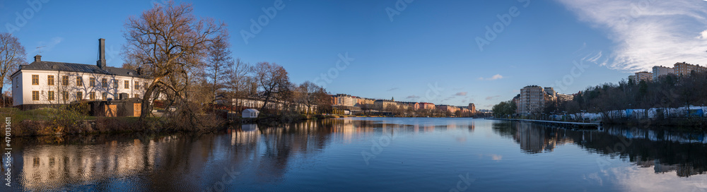Obraz premium Old building at the channel Klarabergskanalen at the castle Karlbergs Slott reflecting in water a sunny autumn day in Stockholm