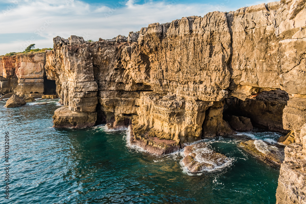 Cliff with cave and waves crashing on the rocks in Boca do Inferno, Cascais PORTUGAL