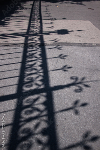 Metal fence cast shadow on sidewalk in the street of Budapest Hungary