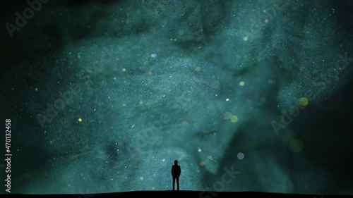 The man stands among the flying shiny particles