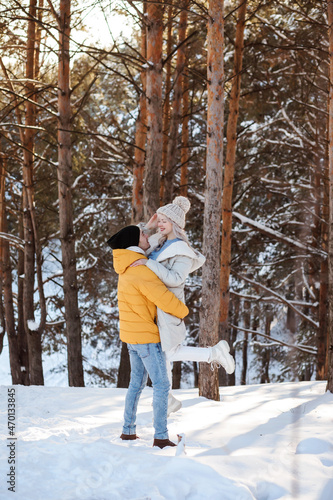 Cute couple is spending time outdoors in winter in the countryside, Christmas holidays.