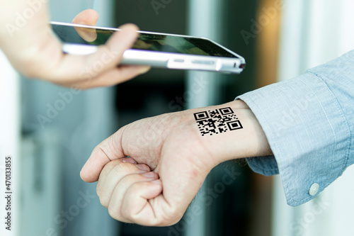 Hand with qr code on wrist. Future of political population control. Chipization of people. Scan the QR code using the mobile application. Proof of completed vaccination and the presence of antibodies photo