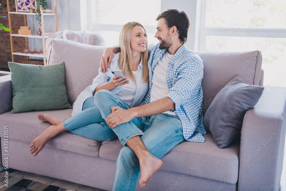Photo of cheerful couple use mobile social network repost sitting divan flat cuddle romance weekend indoors Photo of cheerful couple use mobile social network repost sitting divan flat cuddle romance weekend indoors