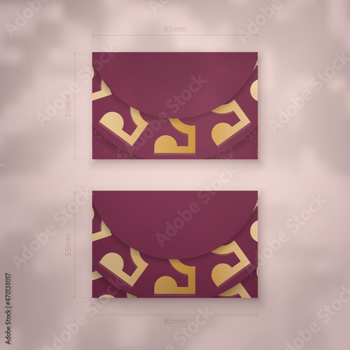 Burgundy business card with antique gold ornament for your contacts.