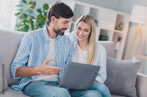 Photo of friendly couple two people sit divan have video call communication wear casual outfit in comfortable home indoors