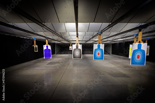 professional Indoor target shooting range looking down range at targets. Assorted targets have bullet holes. photo