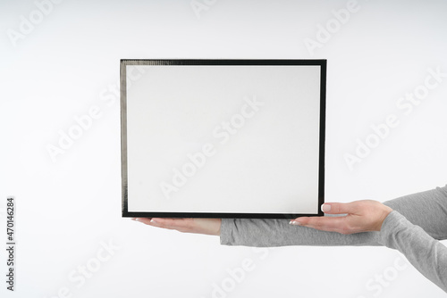 hands hold a black and white box for shoes and storage of things large. parcel packing on white background mockup