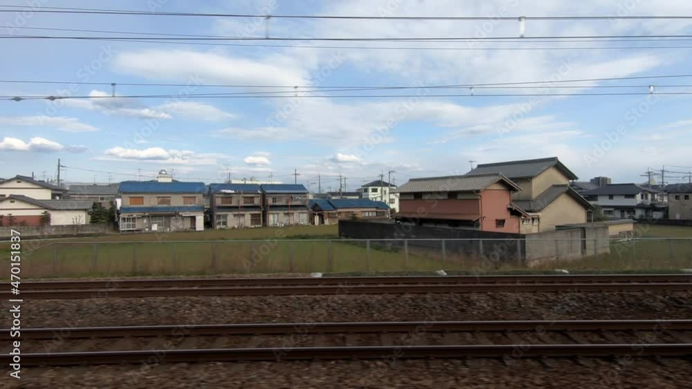Cityscape view through the window from train travels in the city during a beautiful day with blue sky. Trains departing from a railway station. Japanese street with house building. Travel concept.-Dan Cityscape view through the window from train travels in the city during a beautiful day with blue sky. Trains departing from a railway station. Japanese street with house building. Travel concept.-Dan