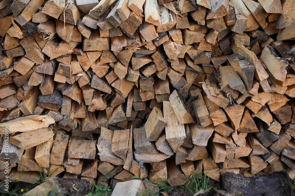 Stack of cut firewood on green grass outdoors Stack of cut firewood on green grass outdoors