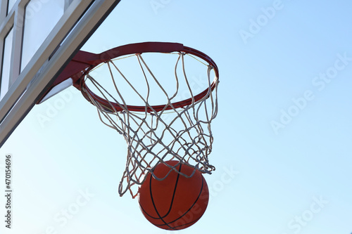 Basketball ball and hoop with net outdoors on sunny day © New Africa