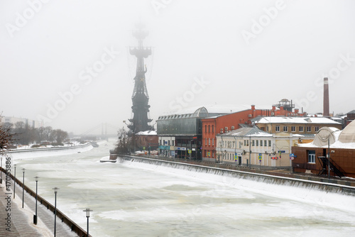 View on the Bolotnaya Embankment, Drainage channel and the bronze monument to Peter the great on the Moscow river on a foggy winter morning. Misty winter morning in Moscow.