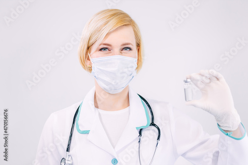 Medical doctor or nurse woman in professional uniform holding ampoule covid-19 vaccine on white background. Medicine and vaccination concept