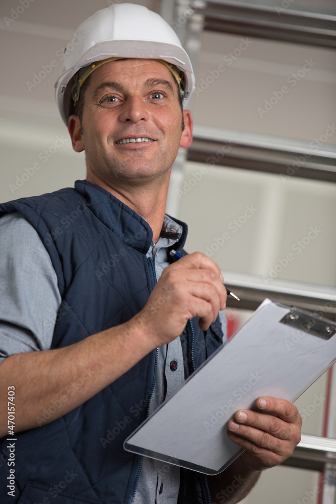 male builder with clipboard at construction site male builder with clipboard at construction site