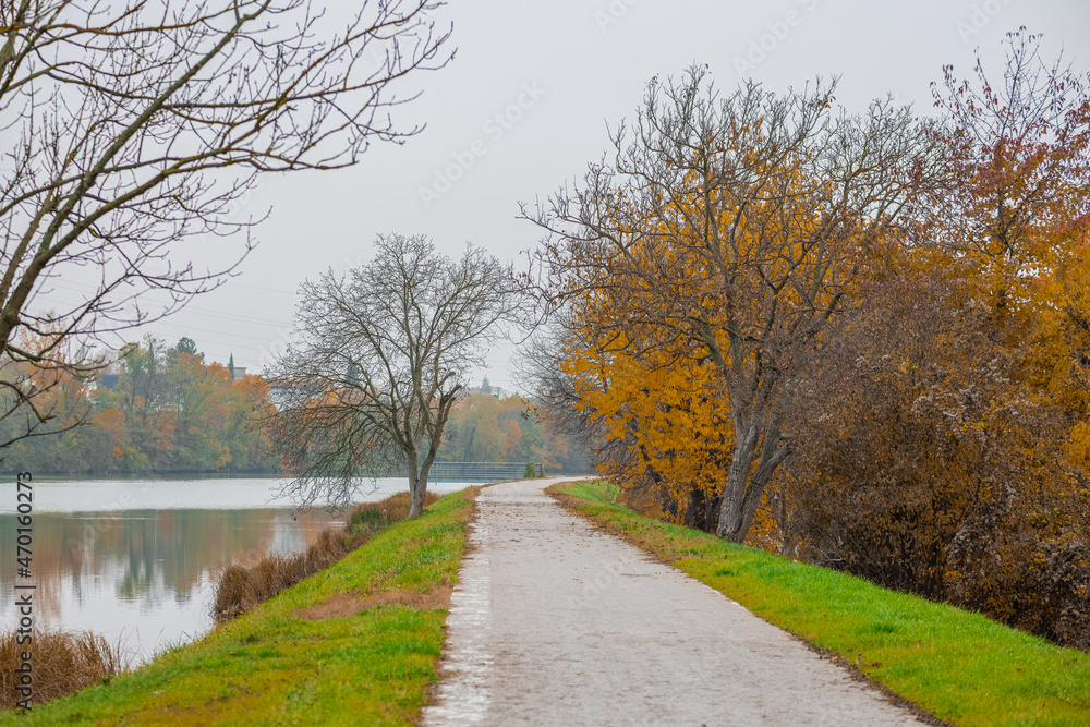 Beautiful path in autumn next to Drava river in Maribor. Fall setting next to a river, lonely cold day.