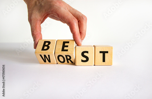 Best or worst symbol. Businessman turns wooden cubes and changes the word best to worst. Beautiful white table, white background, copy space. Business and best or worst concept. photo