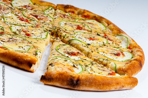 Zucchini pizza with garlic, topped with eggplant and tomato sauce on white background.