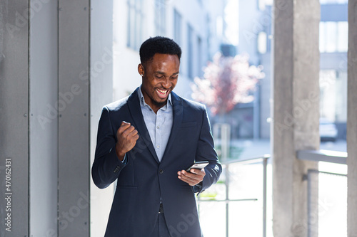 Canvastavla Exited African American Businessman Celebrating Achievement looking at Smartphone