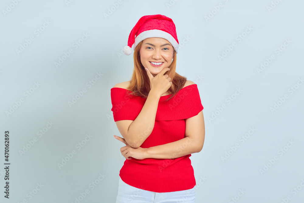 Beautiful young woman wearing christmas dress smiling looking at camera with hand touching chin isolated on white background Beautiful young woman wearing christmas dress smiling looking at camera with hand touching chin isolated on white background