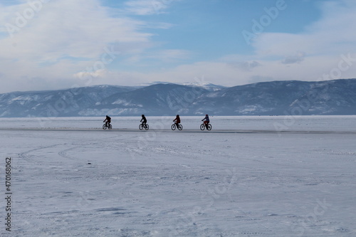 Four cyclists on Baikal lake ice winter 