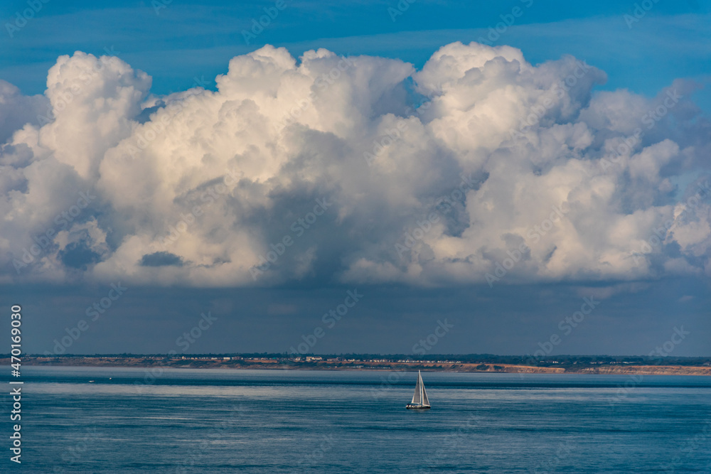 Cloud scape, with sailing boat in the sea