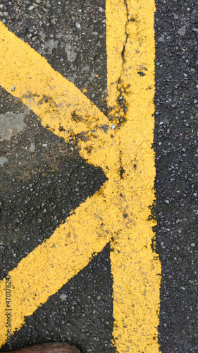 No parking area sign on asphaltic surface. Yellow crossing sign on the textured floor. Yellow stripes on grey background. © Porsche