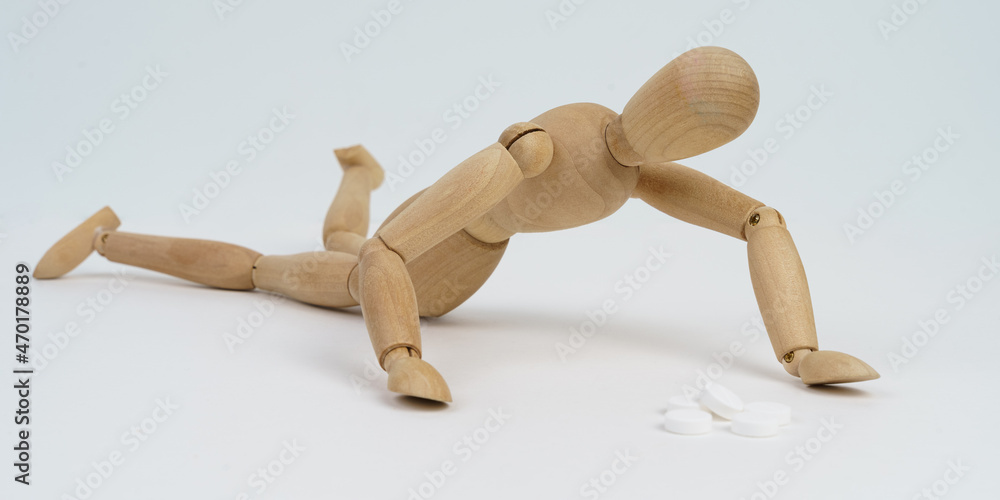 The wooden man crawls for pills. Isolated on white background. The wooden man crawls for pills. Isolated on white background.
