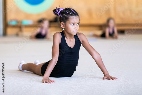 Portrait of upset girl gymnast on training in gym at sports school