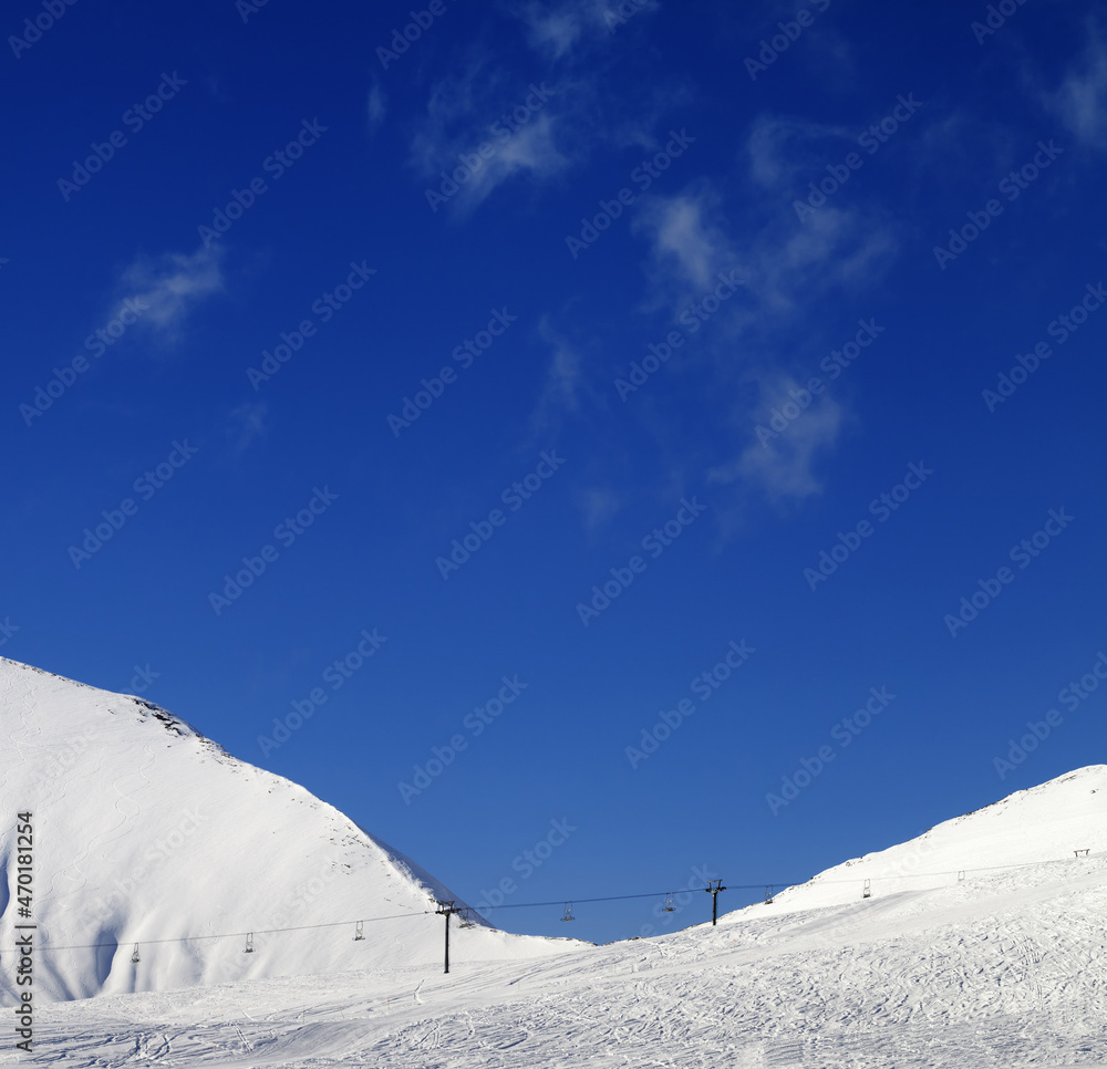 Ski slope with chair lift at sunny winter day