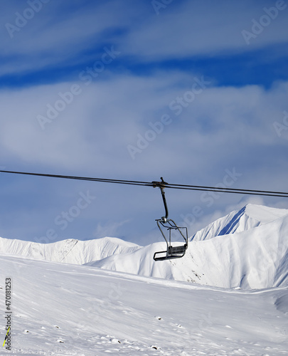 Chair lift and off-piste slope at nice sun day