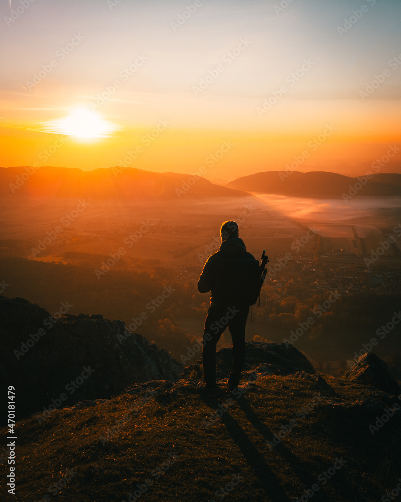 mountaineer standing on the mountain top at sunset in austria
