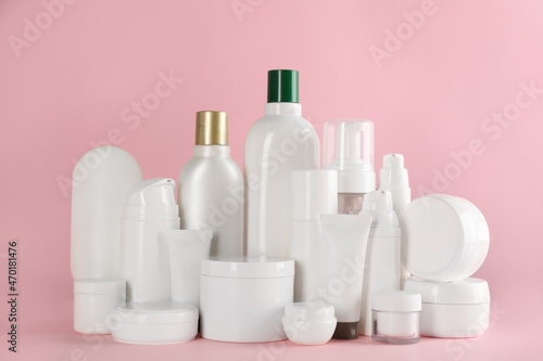 Many different cosmetic products on pink background