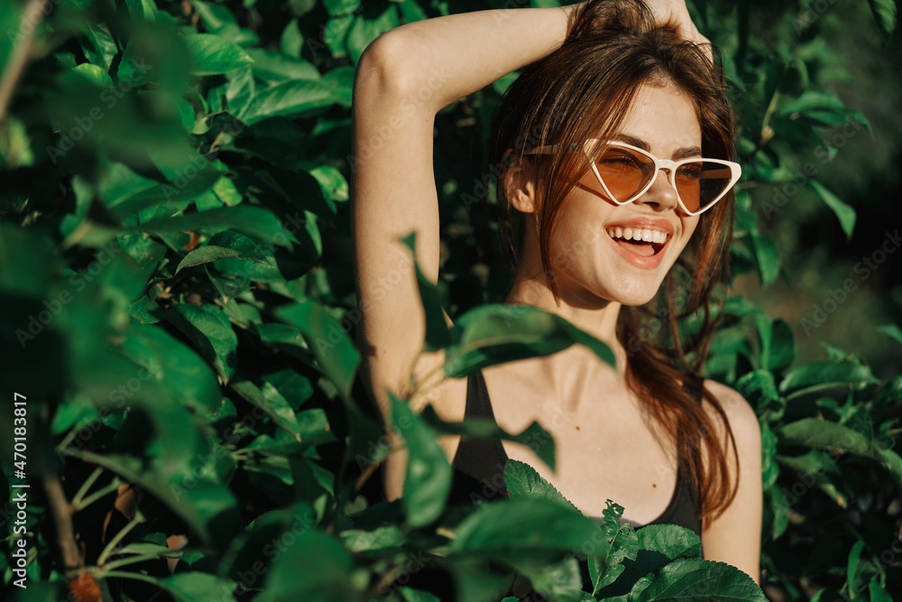 cheerful fashionable woman in sunglasses and green leaves russian summer cheerful fashionable woman in sunglasses and green leaves russian summer