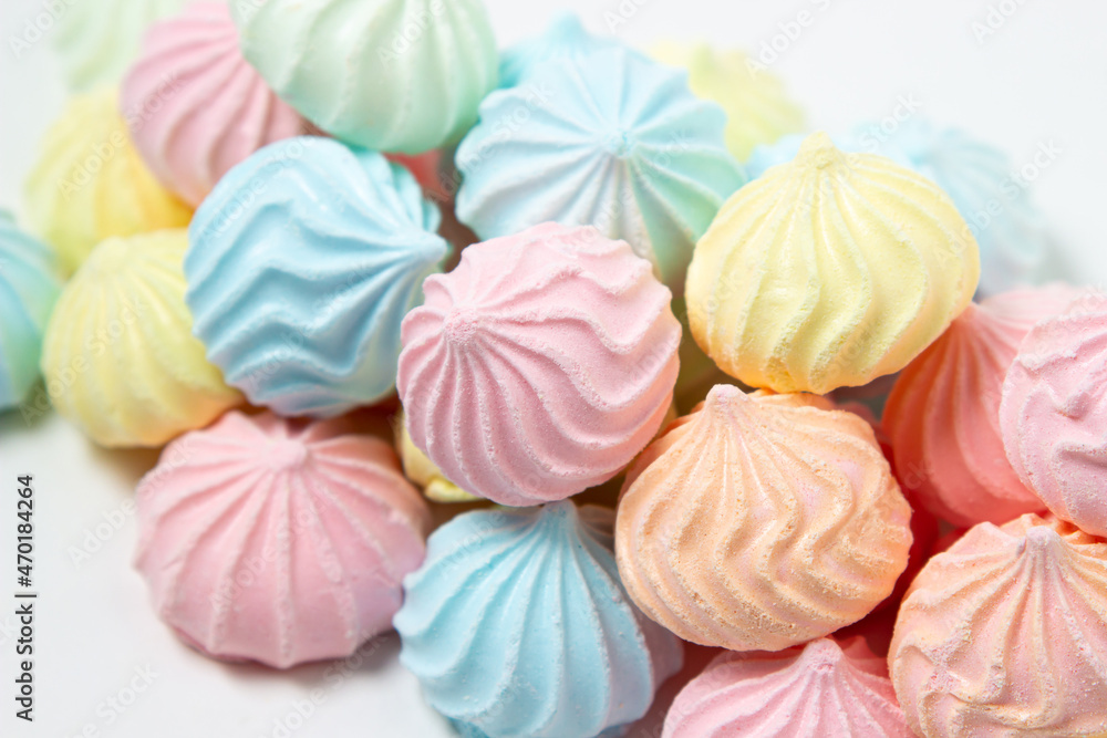 Multicolored meringues on a white background. Light and tasty dessert. Multicolored meringues on a white background. Light and tasty dessert.