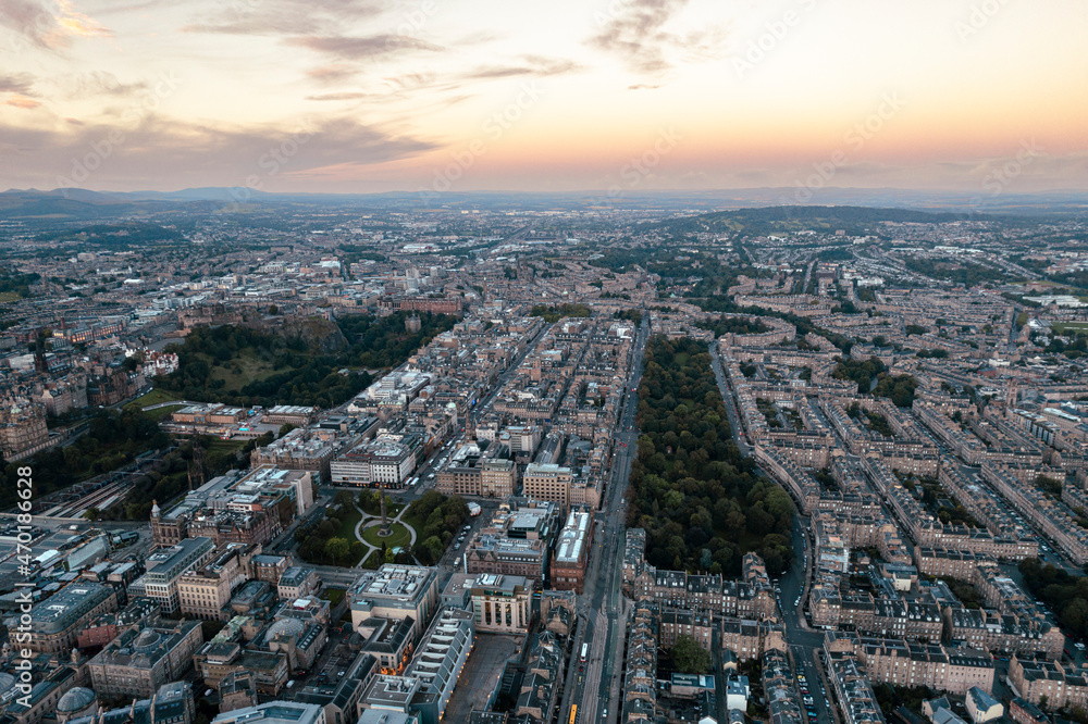 Amazing aerial view of Edinburgh cityscape as sun rises over the city. Old city wakes up with the sunrise. Early morning haze lifts as the first rays of sunlight hit the city of Edinburgh, Scotland