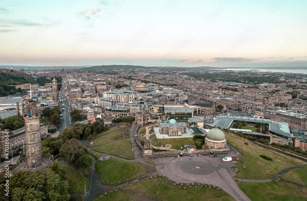 Aerial sunrise view of Calton Hill in Edinburgh, Scotland surrounded by old buildings. Locals use the hill to observe the vastness of the city, enjoy festivals, or attend to spiritual activities