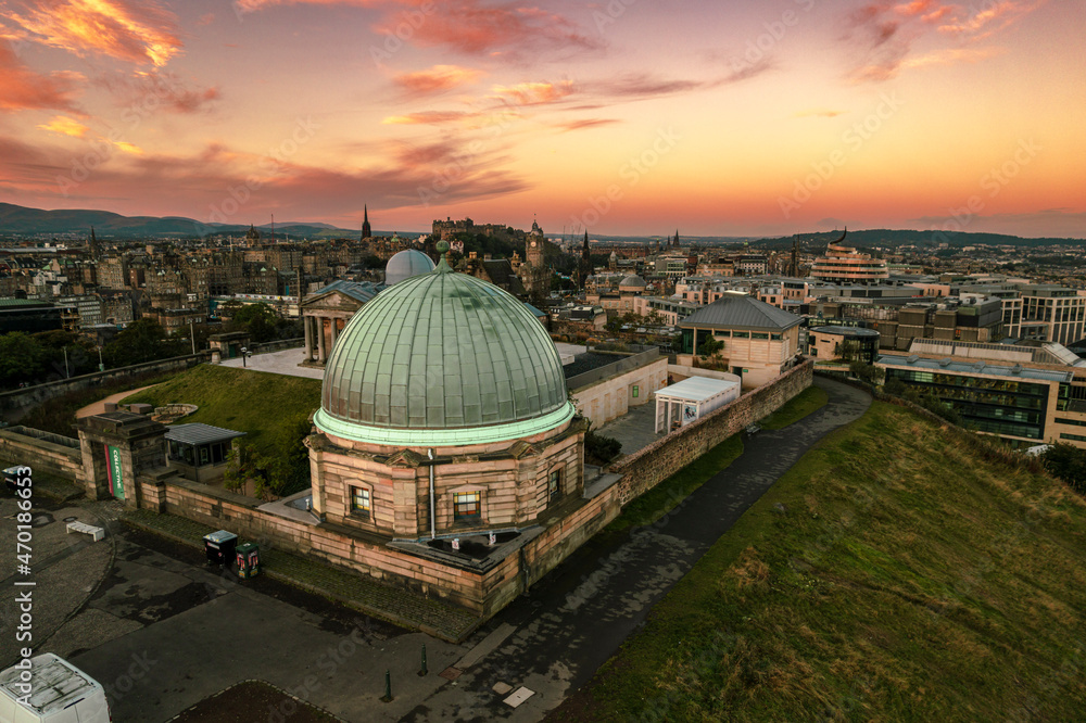 Obraz premium Aerial sunrise view of Calton Hill in Edinburgh, Scotland surrounded by old buildings. Locals use the hill to observe the vastness of the city, enjoy festivals, or attend to spiritual activities